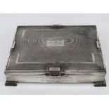 A HM silver cigar box raised over stepped feet and having Art Deco geometric pattern throughout,