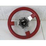 A red leather covered steering wheel marked 'Astrali 1978 patent no 2022764 REG. DES. APP.