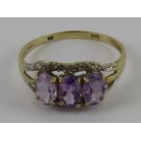 A 9ct gold three stone amethyst ring, stamped 375, size M, 1.5g.