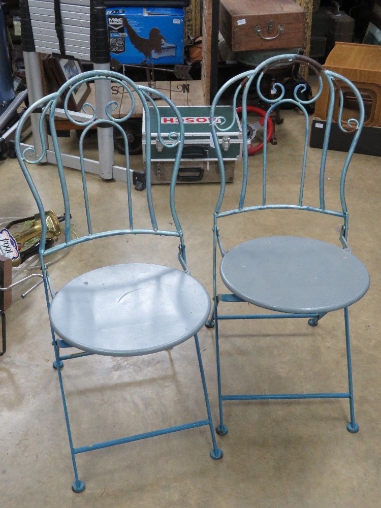 A pair of blue and grey painted metal bistro chairs.