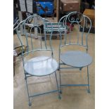 A pair of blue and grey painted metal bistro chairs.