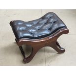 A brown upholstered foot stool having x-shaped frame 57 x 44 x 34cm.