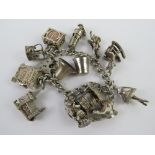 A HM silver charm bracelet with a quantity of large size charms upon including; miners lamp,