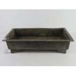 A Chinese rectangular shaped metal planter having three toe dragon and clouds to one side and