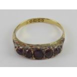 An 18ct gold Victorian ring set with five oval cut foil backed amethyst coloured stones,