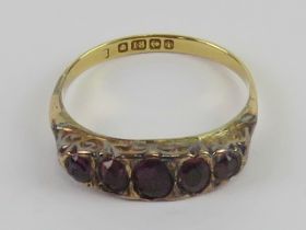 An 18ct gold Victorian ring set with five oval cut foil backed amethyst coloured stones,