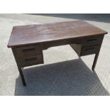 A mid 20th century oak kneehole desk by Abbess having twin drawers to each side and raised over