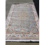 A silk and wool rug in pale blue and cream ground having floral pattern upon and measuring 160 x