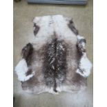 A reindeer hide rug measuring approx 130 x 110cm.