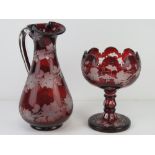 A ruby glass 'Bacchus' claret jug 27cm high, together with a similar footed table centre piece.