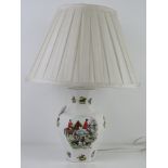 A hunting themed ceramic table lamp with white silk shade, all standing 55cm high.
