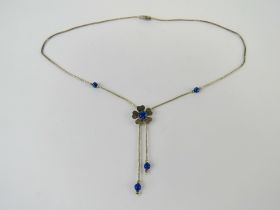 A Native American style silver beaded necklace having blue stone set floral design, marked Sterling.