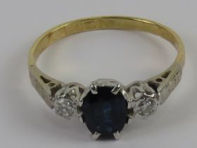 An 18ct gold sapphire and diamond ring, the central blue oval cut sapphire approx 0.