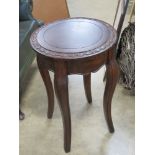 A contemporary occasional table having carved floral border and raised over shaped legs, 41cm dia,