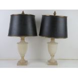 A pair of alabaster table lamps in the form of classical urns having black and gilt painted metal