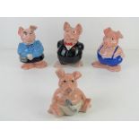 A set of four NatWest pig money banks by Wade, three having original black NatWest stoppers.