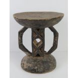 A hand carved and ebonised wooden stool of African origin and measuring 28.5cm dia, 32cm high.