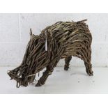 A wicker garden figurine of a pig 52cm in length. a/f.