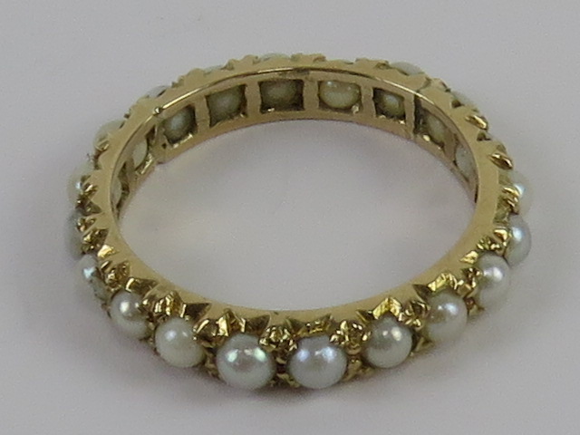 A 9ct gold and pearl eternity ring, hallmarked for London with makers mark, size M, 2.1g.