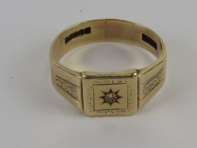 A 9ct gold signet ring having star set single diamond to centre, hallmarked 375, size S, 4.3g.