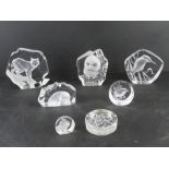 A quantity of Mats Jonasson crystal paperweights together with a Dartington paperweight.