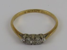 A vintage three stone illusion set diamond ring, 18ct gold and platinum setting, size L, 1.6g.