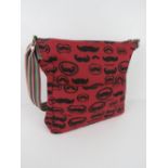 A fabric tote bag having mustache pattern in red 'as new', approx 38 x 34cm.