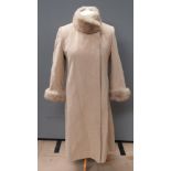 A felted woolen coat with faux fur collar and sleeves, labels having been removed,