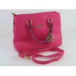 A contemporary hot pink handbag, 30cm wide.