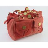 Ted Baker; a coral suede handbag having floral lining, approx 30cm wide.