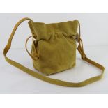 A yellow suede leather bucket style handbag by Urban Outfitter, approx 16cm wide.