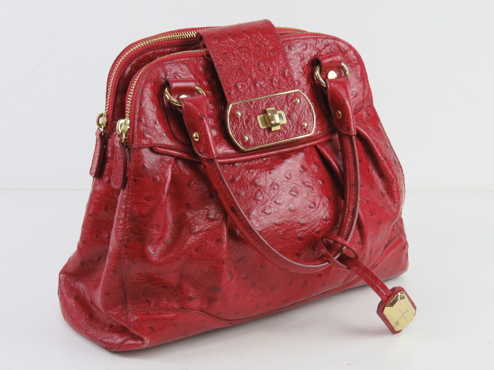 Jasper Conran; a red leather handbag having three sectional compartment approx 37cm wide.