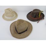 A contemporary straw trilby together with another similar and a souvenir type Swiss Alps hat.