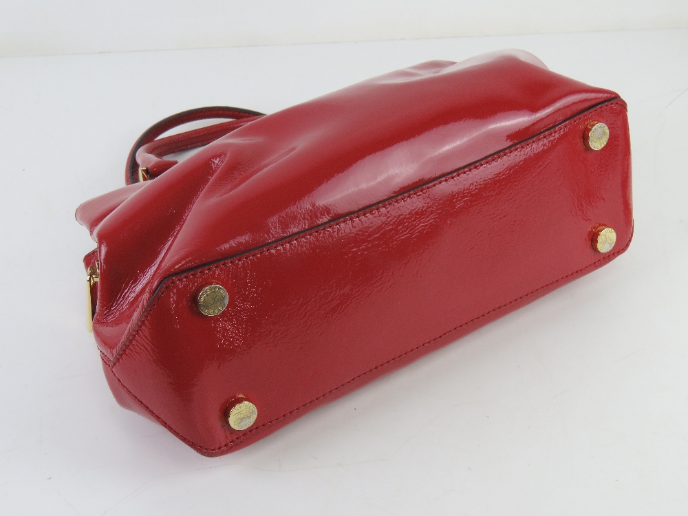 Michael Kors; a red patent handbag with original paper shopping bag and dust bag, approx 31cm wide. - Image 3 of 4