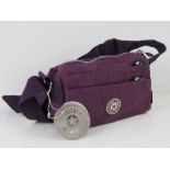 An 'as new' fabric handbag in purple measuring 21 x 15cm.