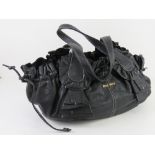 A black leather handbag marked for Miu Miu, unauthenticated, having purple satin type lining,