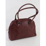 A vintage burgundy leather handbag marked for Gucci, unauthenticated, approx 30cm wide.