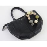 Radley; a small black leather handbag with key chain upon approx 19cm wide.