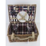 A wicker picnic hamper for two including cutlery, plates and plastic glasses, 41 x 27 x 18cm.
