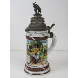 A military themed ceramic beer stein having pewter lid with horned goat upon, of German manufacture.