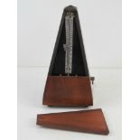 A late 20thC pyramidal mahogany cased clockwork metronome standing approx 22cm high. Full working