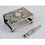 A large size HM silver matchbox cover raised over ball feet,