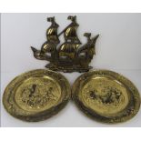 A brass wall hanging decoration in the form of a ship approx 38cm wide, and a pair of embossed brass