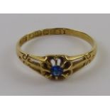 An 18ct gold ring having blue stone (possibly tanzanite) to central floral pierced design,