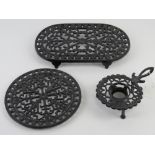 Three contemporary cast iron and painted trivets of various forms.
