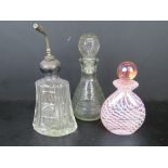 A Sterling silver and cut glass perfume bottle together with two other glass bottles. Three items.