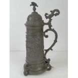 A late 19thC pewter lidded beer stein dated 5th July 1899, having winged mermaid style feet and