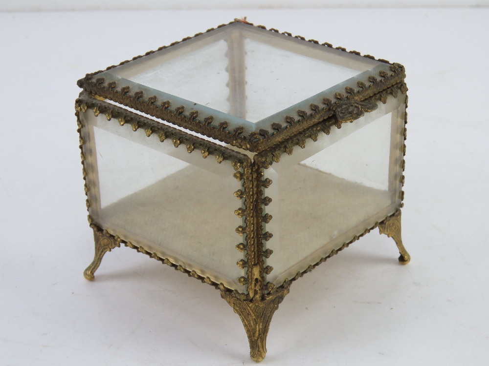 A c1950s Stylebuilt glass and gilt metal jewellery box having five bevel edged glass sides and