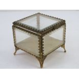 A c1950s Stylebuilt glass and gilt metal jewellery box having five bevel edged glass sides and