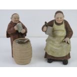 Two bisque figurines of beer making monks.